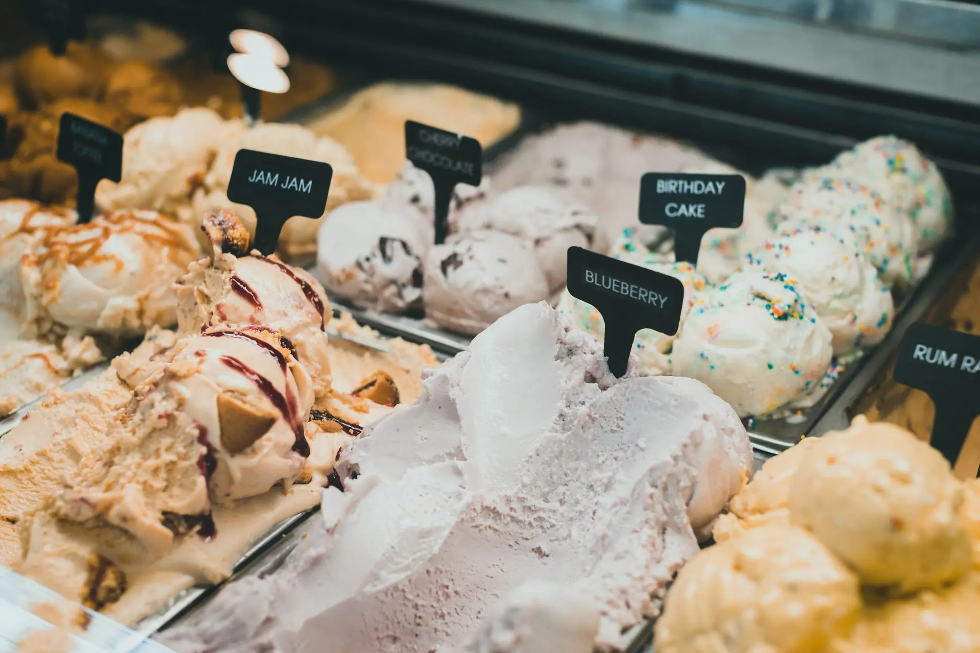 Copa de helado artesano con cuchara dorada sobre fondo oscuro
